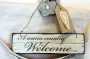 A peg bag with a decorative welcome sign hanging from it.